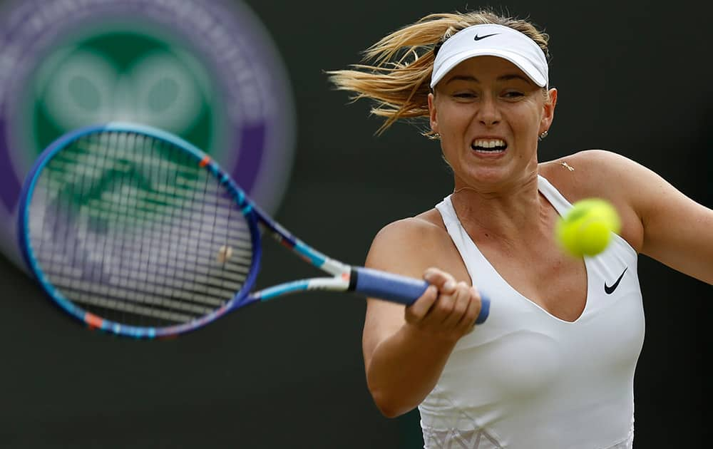 Maria Sharapova of Russia makes a return to Irina-Camelia Begu of Romania, during their singles match at the All England Lawn Tennis Championships in Wimbledon.