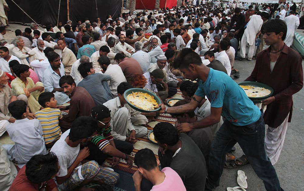 Pakistani volunteers give food to devotees to break the day's fast, which many Muslims practice during the month of Ramadan, in Karachi, Pakistan.
