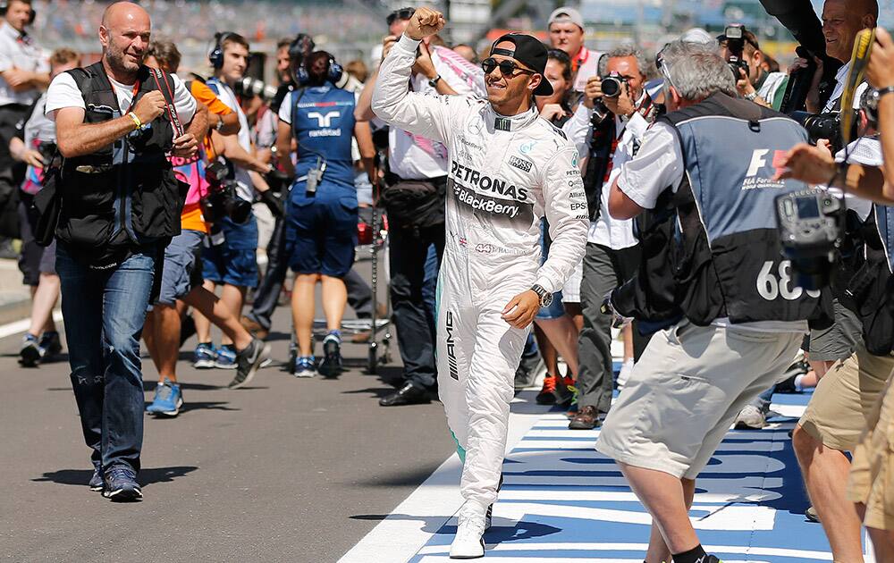 British Mercedes driver Lewis Hamilton, center, is surrounded by photographers as he celebrates after he captured the pole position during the qualyfying for the British Formula One Grand Prix at Silverstone circuit, Silverstone, England.