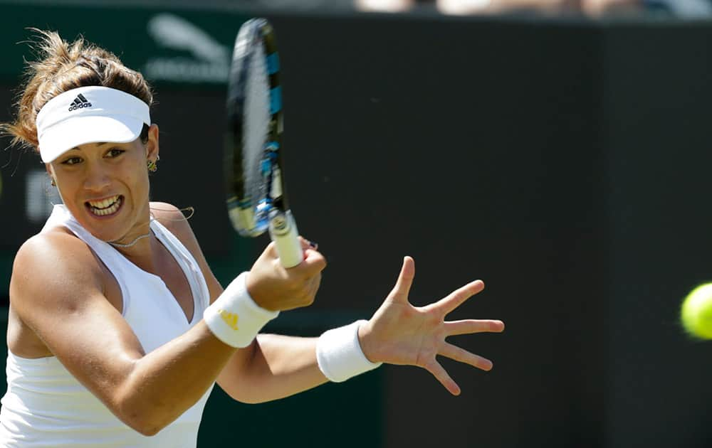 Garbine Muguruza of Spain plays a return to Angelique Kerber of Germany during their singles match at the All England Lawn Tennis Championships in Wimbledon, London.