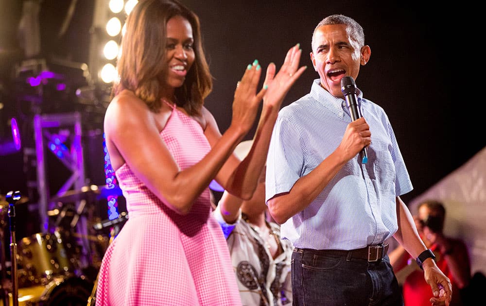 President Barack Obama, accompanied by first lady Michelle Obama, left, speaks during an Independence Day celebration on the South Lawn at the White House in Washington.