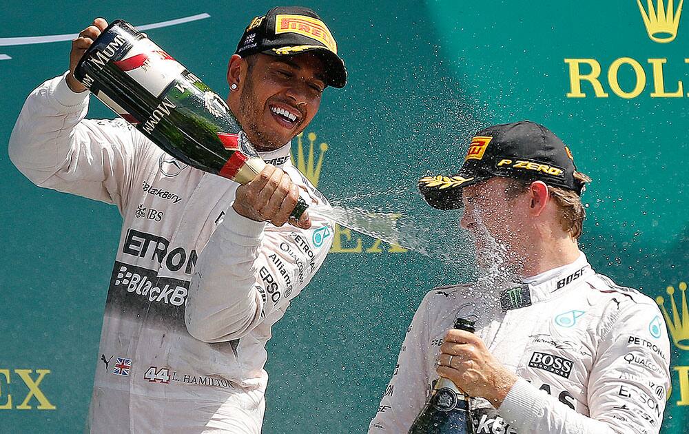 British Mercedes driver Lewis Hamilton, left, and German Mercedes driver Nico Rosberg celebrate after the British Formula One Grand Prix at Silverstone circuit, Silverstone, England.