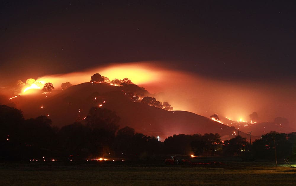 This 16-second time exposure shows a wildfire that might have been started by fireworks and burned more than 320 acres while threatening homes in the Northern California city of Vacaville.