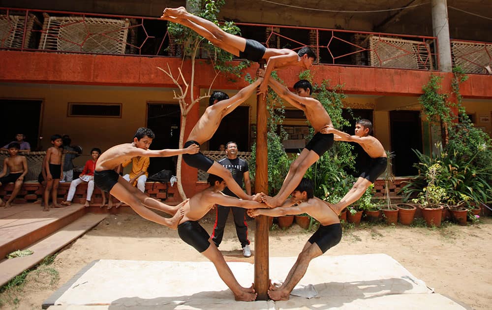 Indian boys practice Mallakhamb, a traditional Indian gymnastic sport on a vertical wooden pole ahead of upcoming chariot festival of Lord Jagannath in Ahmadabad, India.