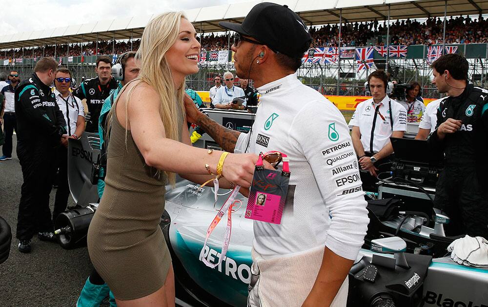 Mercedes formula one driver Lewis Hamilton receives a kiss from olympic skier Lynsey Vonn of the U.S. ahead of the British Grand Prix at the Silverstone Race Circuit, Britain.