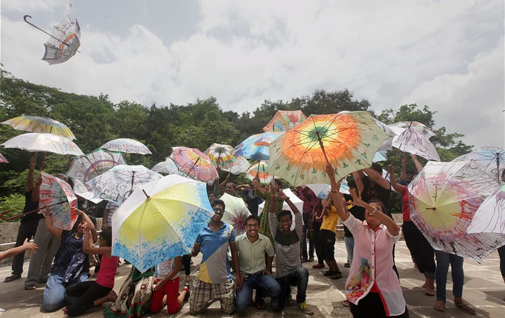 People take part in an Umbrella Workshop where people paint umbrellas with colors in Navi Mumbai.