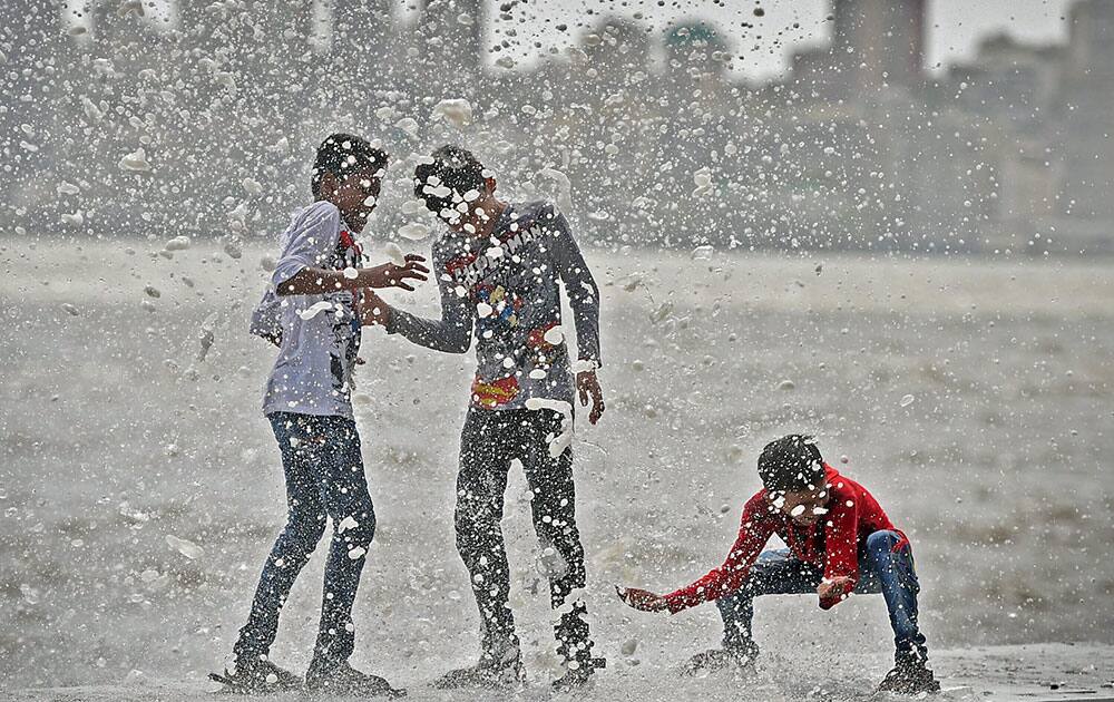 Children enjoy high tide at Marine Drive in Mumbai.