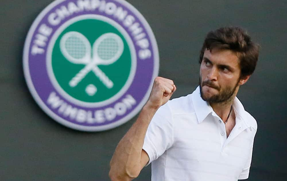 Gilles Simon of France celebrates after winning the third set against Gael Monfis of France during their singles match at the All England Lawn Tennis Championships in Wimbledon, London.