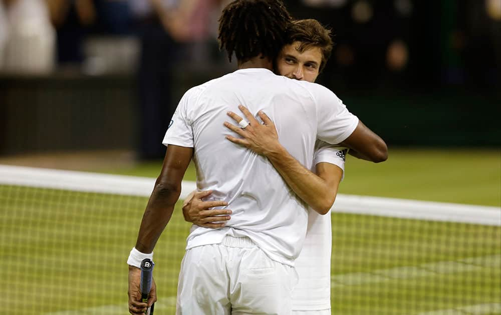 Gilles Simon of France, right, embraces Gael Monfils of France after winning the singles match at the All England Lawn Tennis Championships in Wimbledon, London.