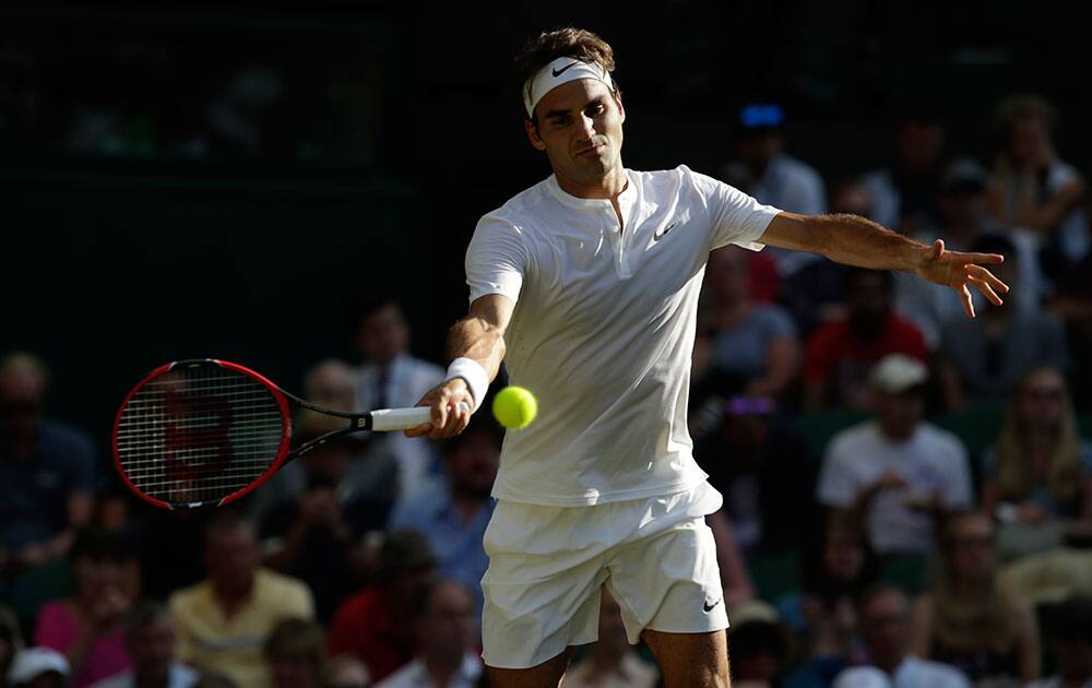 Roger Federer of Switzerland makes a return to Roberto Bautista Agut of Spain during their singles match against at the All England Lawn Tennis Championships in Wimbledon, London.