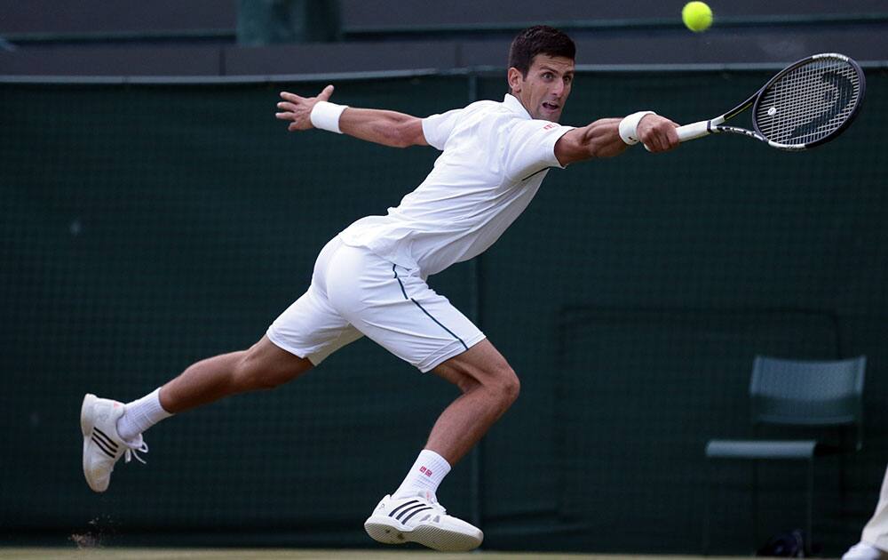 Novak Djokovic of Serbia returns a ball to Kevin Anderson of South Africa during their singles match against at the All England Lawn Tennis Championships in Wimbledon, London.