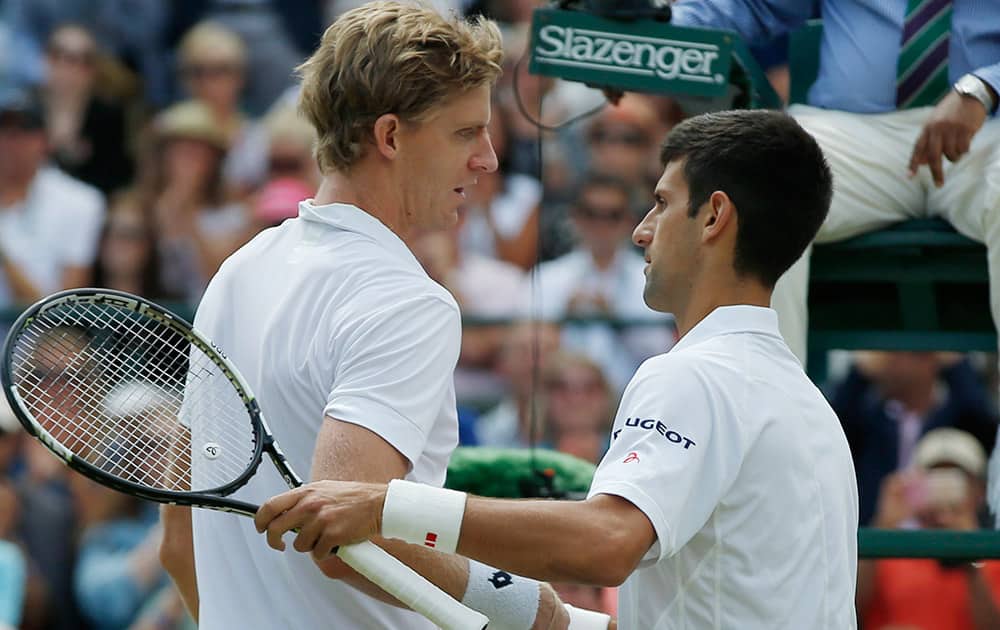 Novak Djokovic of Serbia shakes hands at the net with Kevin Anderson of South Africa, after winning their singles match, at the All England Lawn Tennis Championships in Wimbledon, London. Djokovic won 6-7, 6-7, 6-1, 6-4, 7-5.