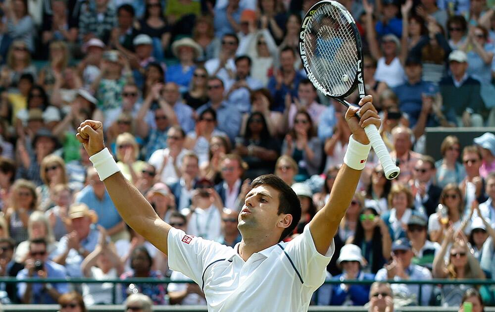 Novak Djokovic of Serbia celebrates winning the singles match against Kevin Anderson of South Africa, at the All England Lawn Tennis Championships in Wimbledon, London. Djokovic won 6-7, 6-7, 6-1, 6-4, 7-5.