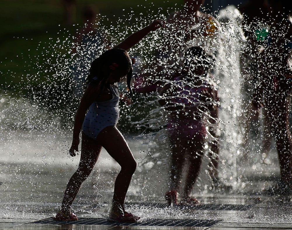 Children play as they cool down in a fountain in a park as a heatwave continues in most parts of Spain with temperatures reaching around 40 degrees Celsius (104 degrees Fahrenheit), Madrid, Spain.