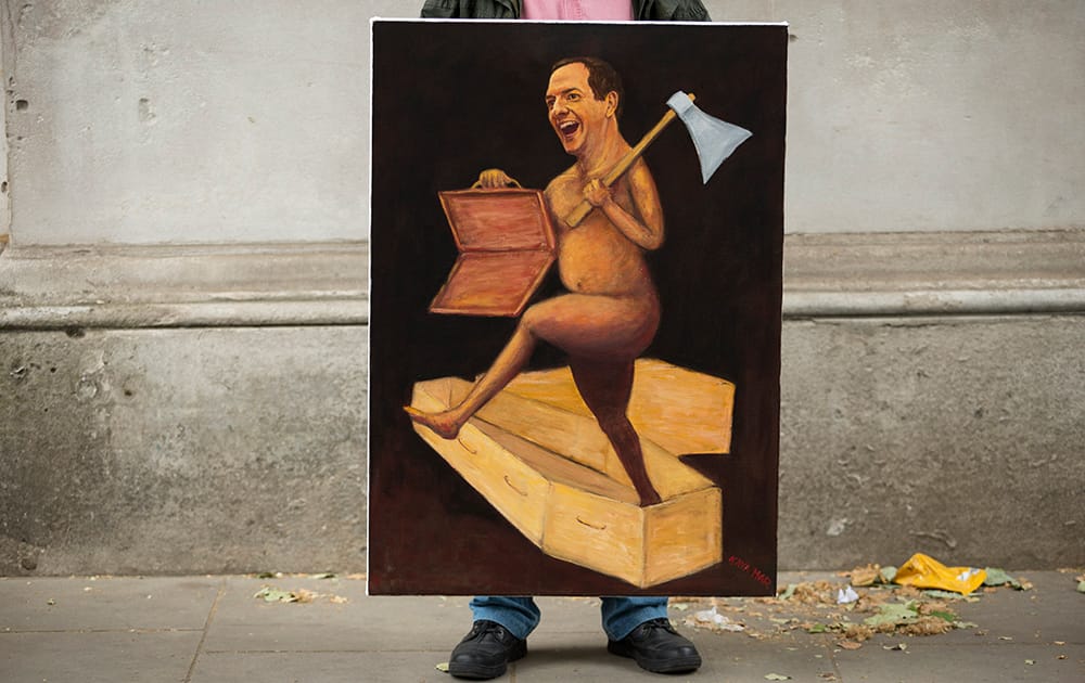 Artist Kaya Mar holds his painting of British Chancellor of the Exchequer George Osborne on budget day outside Downing Street in London.