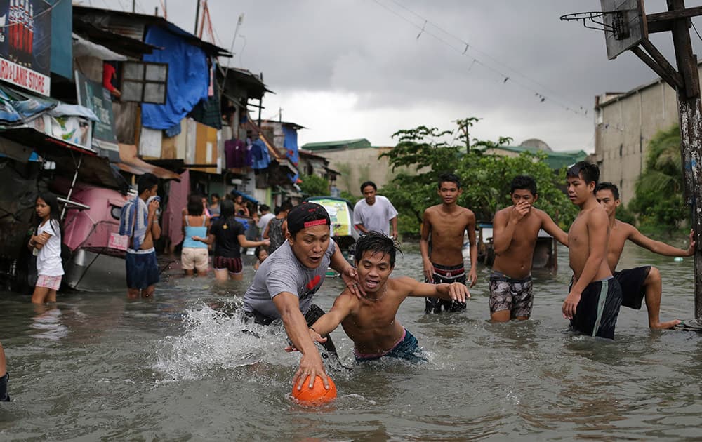 Filipino boys scramble for a ball possession as they play basketball in floodwaters from a swollen creek at a coastal village in Malabon, north of Manila, Philippines.