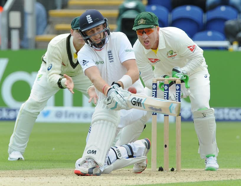 England’s Joe Root plays a shot watched by Australia’s wicket keeper Brad Haddin during day one of the first Ashes Test cricket match, in Cardiff, Wales.