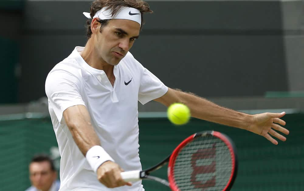 Roger Federer of Switzerland plays a return to Gilles Simon of France during the men's quarterfinal singles match at the All England Lawn Tennis Championships in Wimbledon, London.