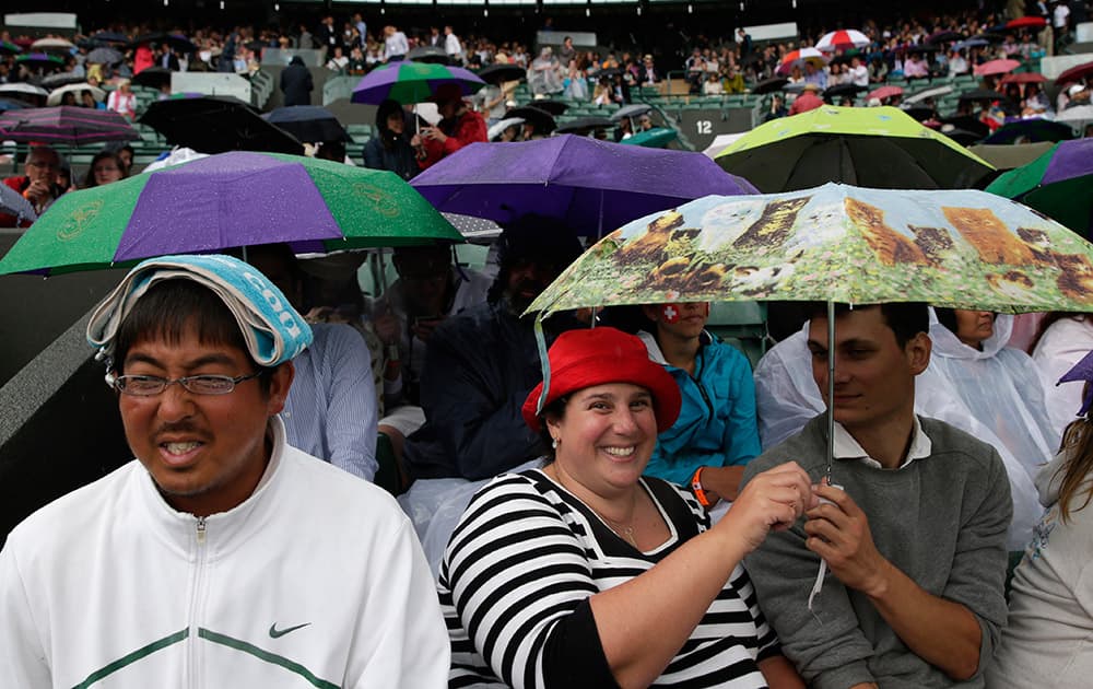 Spectators shelter from the rain on No.1 Court, at the All England Lawn Tennis Championships in Wimbledon, London.