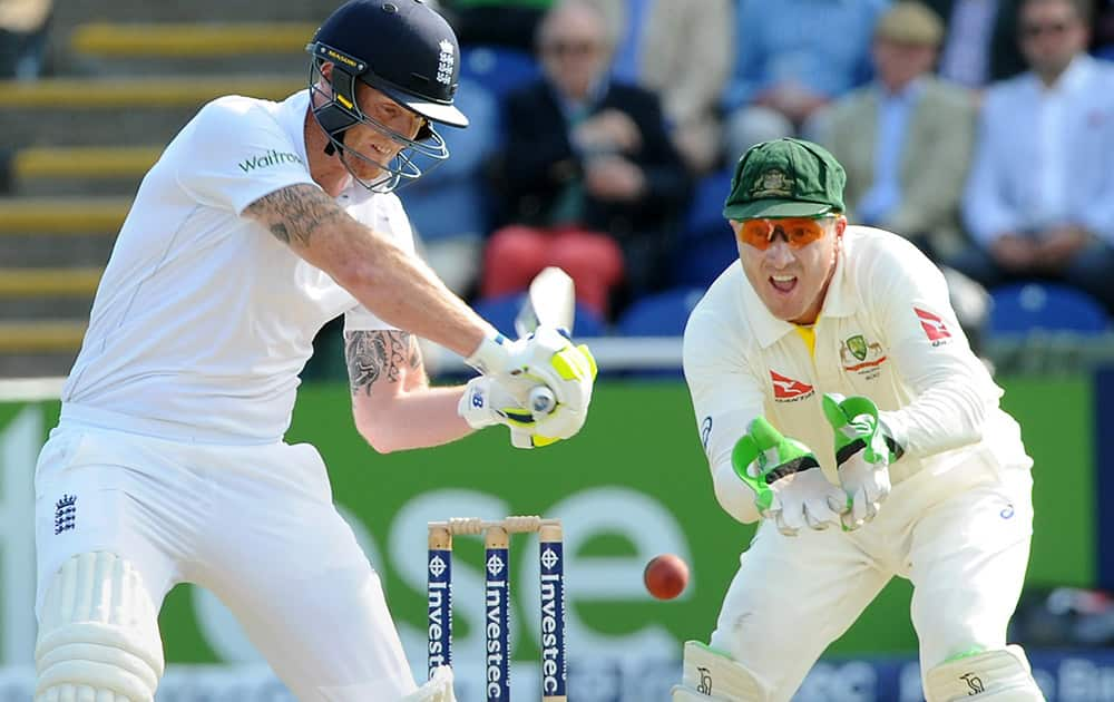 England’s Ben Stokes plays a shot watched by Australia's Brad Haddin during day one of the first Ashes Test cricket match, in Cardiff, Wales.