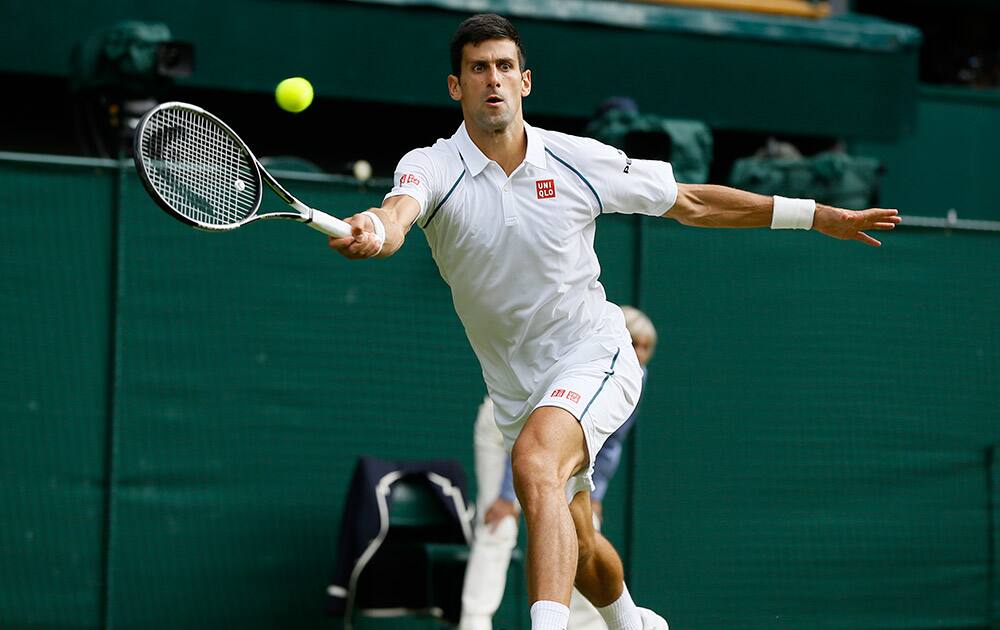 Novak Djokovic of Serbia returns a shot to Marin Cilic of Croatia during their singles match against at the All England Lawn Tennis Championships in Wimbledon, London.