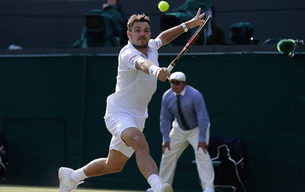 Stan Wawrinka of Switzerland makes a return to Richard Gasquet of France, during the men's quarterfinal singles match at the All England Lawn Tennis Championships in Wimbledon, London.