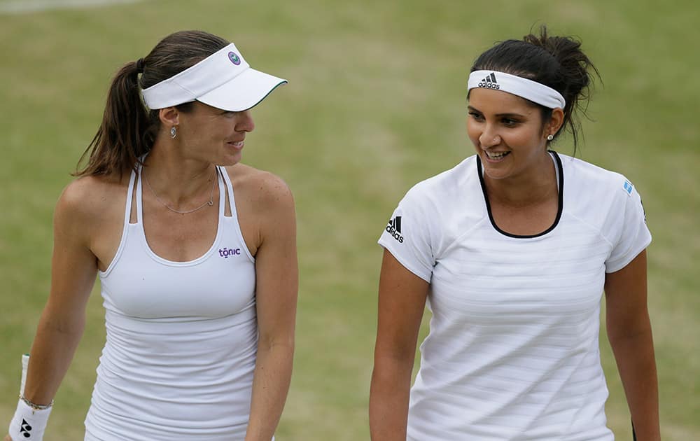 Martina Hingis from Switzerland and Sania Mirza from India talk between points during their doubles match against Casey Dellacqua from Australia and Yaroslava Shvedova from Kazakhstan at the All England Lawn Tennis Championships in Wimbledon, London.