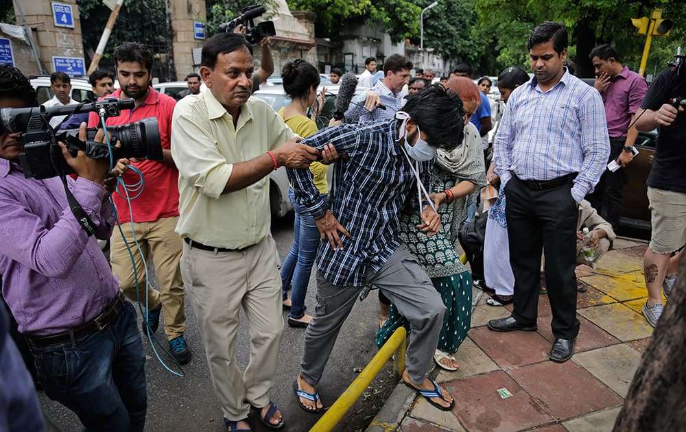 Puneet Kumar, accused of driving drunk in a hit-and-run car accident that killed an Australian student in Melbourne in 2008, is helped by his parents as they come out after being produced at a court in New Delhi, India