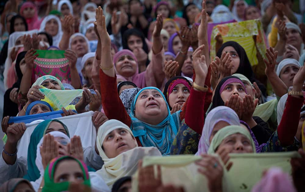 Kashmiri Muslim devotees raise their hands in prayer as a head priest displays a relic of the Prophet Muhammad at the Hazratbal shrine, during the Martyr Day of Hazrat Ali, in Srinagar.