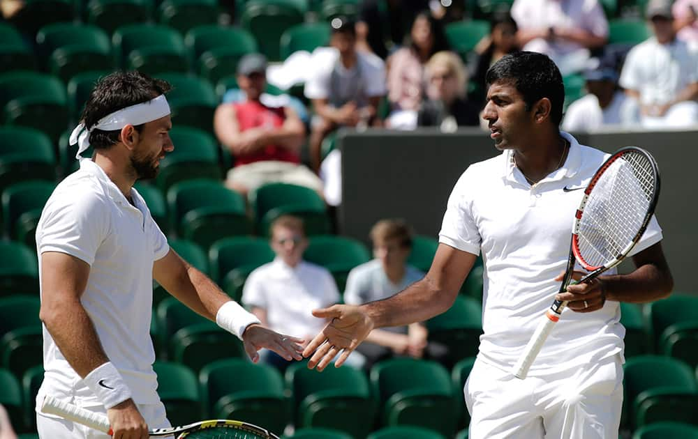 Rohan Bopanna and Florin Mergea of Romania talk between points during the men's semifinal doubles match against Jean-Julien Rojer of the Netherlands and Horia Tecau of Romania at the All England Lawn Tennis Championships in Wimbledon, London.