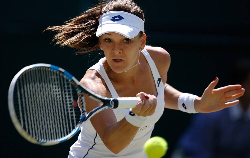 Agnieszka Radwanska of Poland returns a shot to Garbine Muguruza of Spain during the women's singles semifinal match at the All England Lawn Tennis Championships in Wimbledon, London.