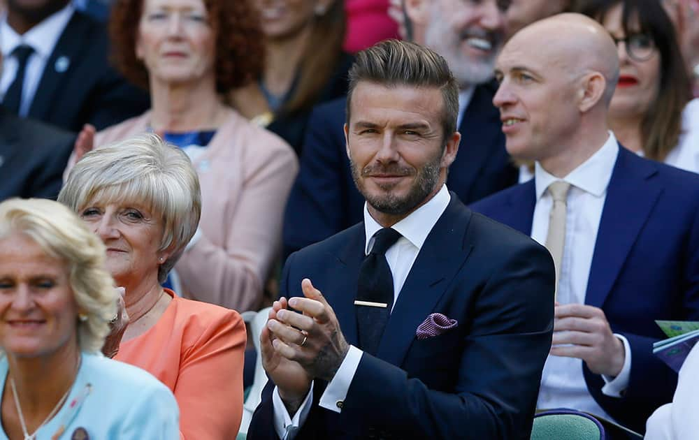 Former soccer player David Beckham and his mother Sandra, applaud during the women's singles semifinal match between Garbine Muguruza of Spain and Agnieszka Radwanska of Poland, at the All England Lawn Tennis Championships in Wimbledon, London.