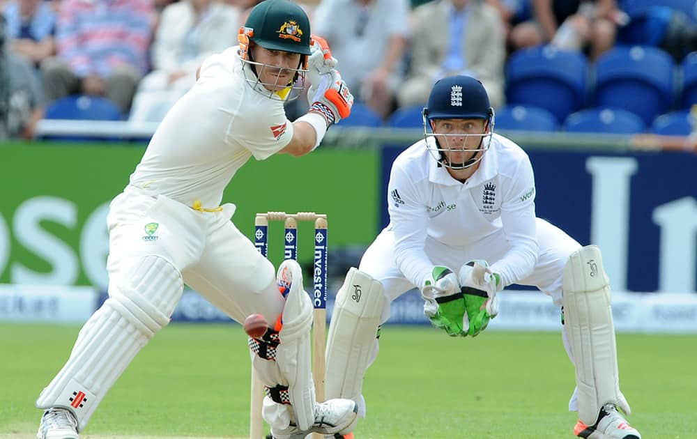 Australia’s David Warner plays a shot watched by England's Jos Buttler during day two of the first Ashes Test cricket match, in Cardiff, Wales.