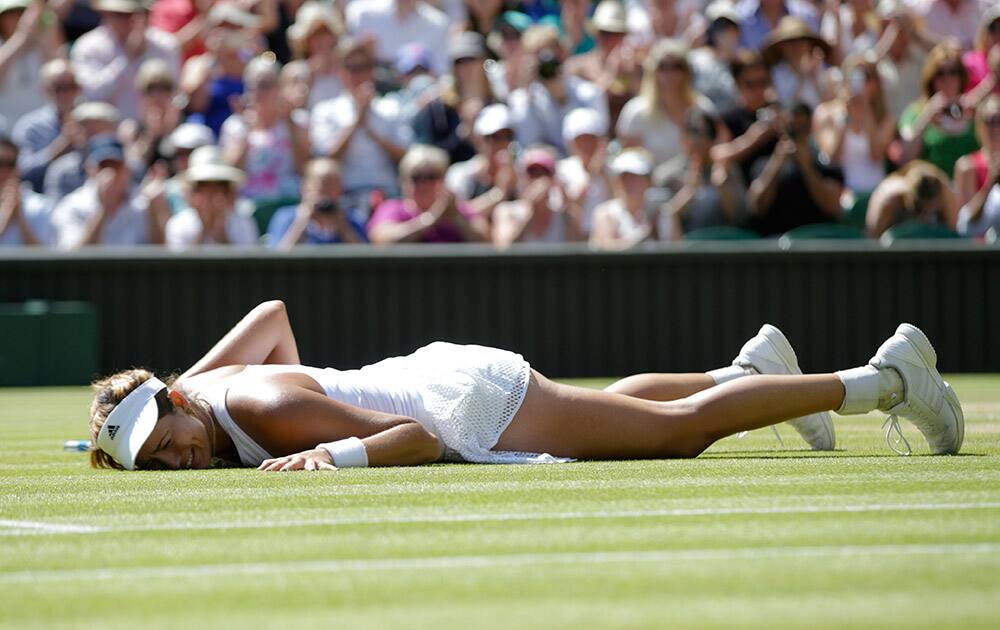 Garbine Muguruza of Spain lies on the court after defeating Agnieszka Radwanska of Poland during their women's singles semifinal match at the All England Lawn Tennis Championships in Wimbledon, London. Muguruza won 6-3, 3-6, 6-3.