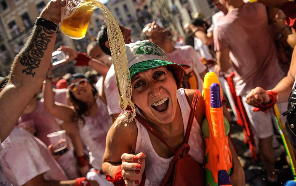Revelers celebrate during the launch of the 'Chupinazo' rocket, to celebrate the official opening of the 2015 San Fermin Fiestas, in Pamplona, northern Spain.