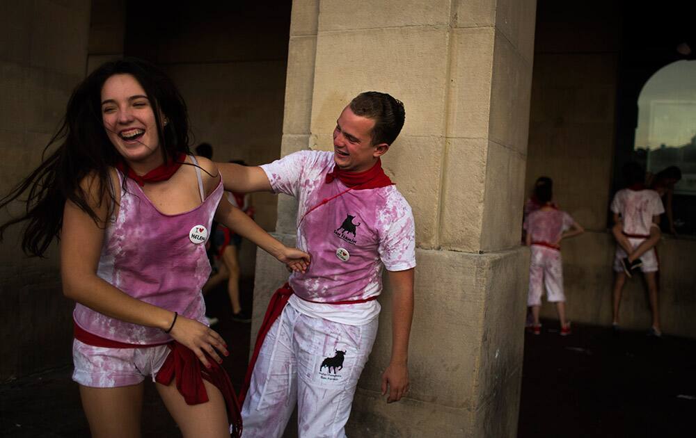Revelers with their clothes covered in wine laugh during the San Fermin festival, in Pamplona, Spain.