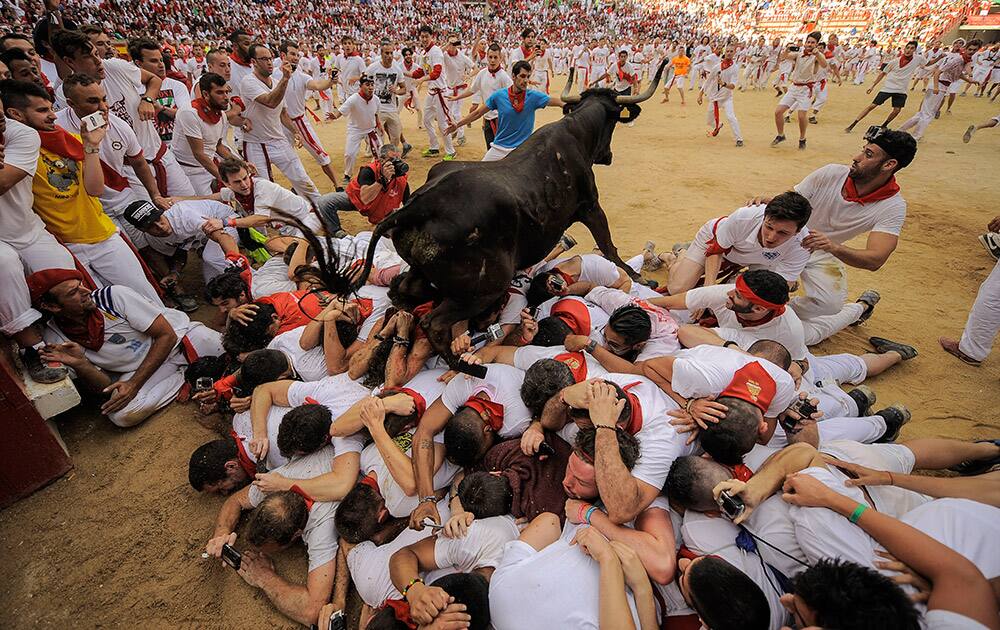 A cow jumps over a group of revelers on the bull ring, at the San Fermin Festival, in Pamplona, Spain.