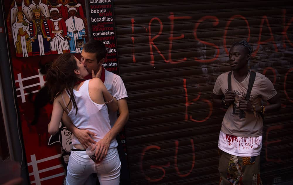 A couple kiss early in the morning before the start of the third running of the bulls, at the San Fermin Festival, in Pamplona, Spain.