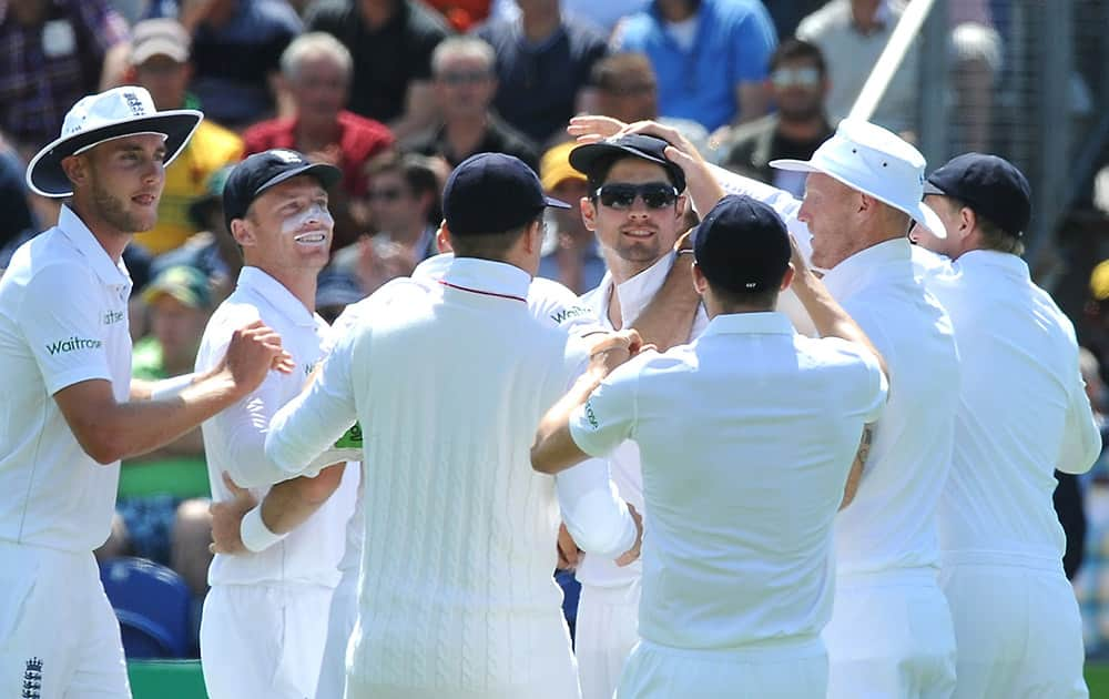 England’s Alastair Cook is congratulated by teammates after he caught Australia's David Warner bowled by England's James Anderson for 17 runs during day two of the first Ashes Test cricket match, in Cardiff, Wales.