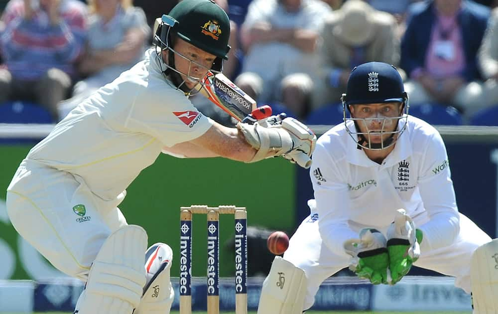 Australia’s Chris Rogers watched by England's wicket keeper Jos Buttler as he plays a shot during day two of the first Ashes Test cricket match, in Cardiff, Wales.