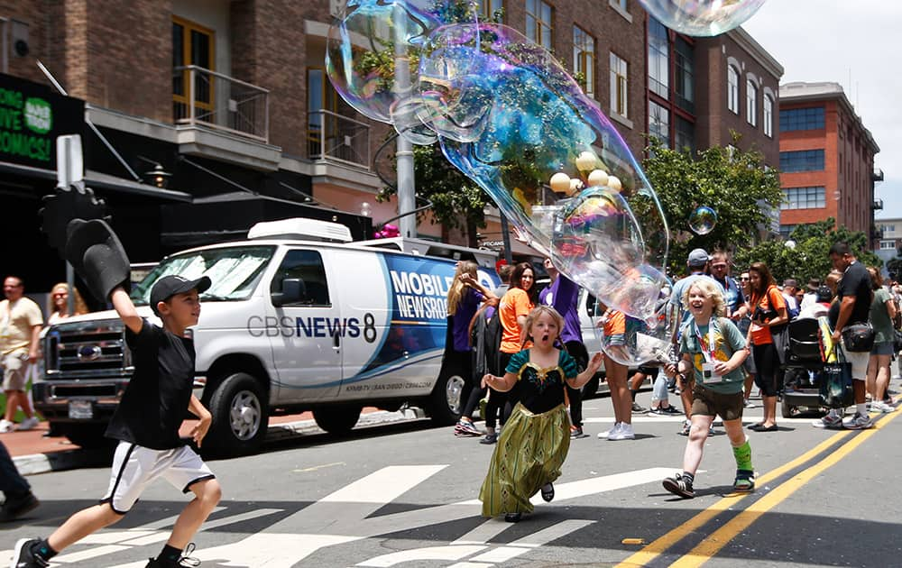 Children chase giant balloons on the streets of the Gas Lamp District on opening day of the 2015 Comic-Con International convention, in San Diego. 