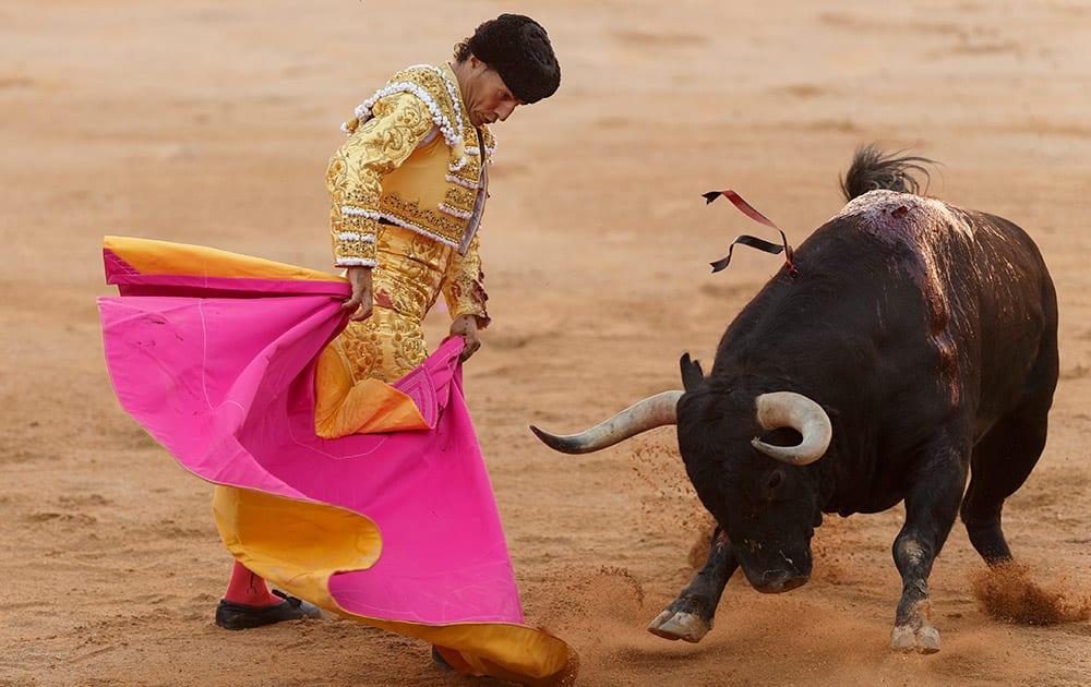 Spanish bullfighter Ivan Fandino performs with a Victoriano del Rio ranch fighting bull during a bullfight of the San Fermin festival in Pamplona, Spain.