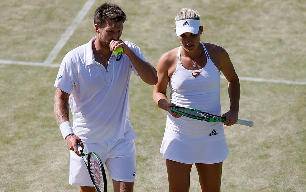 Alexander Peya of Austria and Timea Babos of Hungary talk between points during the mixed doubles quarterfinal match against Bruno Soares of Brazil and Sania Mirza of India at the All England Lawn Tennis Championships in Wimbledon.