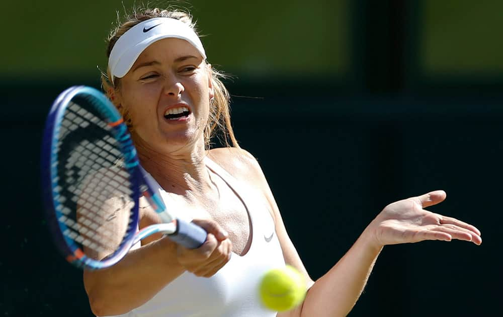 Maria Sharapova of Russia returns a shot to Serena Williams of the United States, during the women's singles semifinal match at the All England Lawn Tennis Championships in Wimbledon, London.