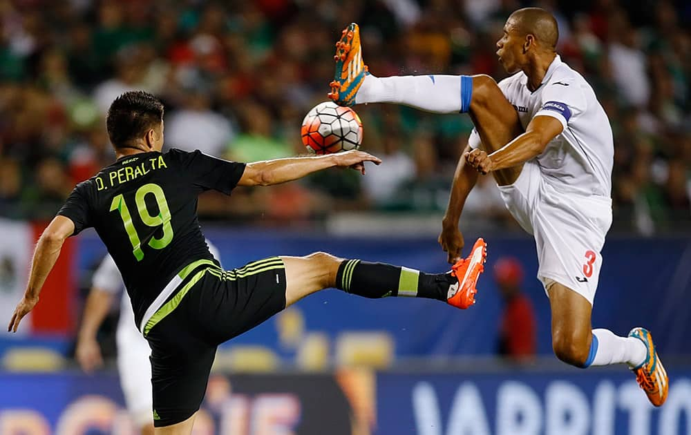 Mexico forward Oribe Peralta (19) leaps for the ball with Cuba defender Yenier Marquez (3) during the first half of a CONCACAF Gold Cup soccer match, in Chicago. 