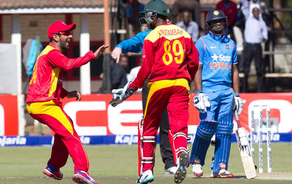 Zimbabwean players Sikanda Raza and Richmond Mutumbami celebrate the wicket of Indian batsman Kedar Jadhav after he was caught behind during the first One Day International between the two teams in Harare, Zimbabwe.