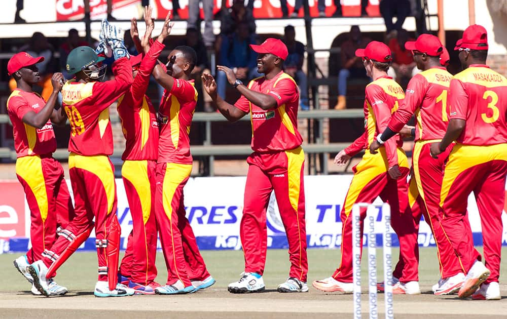 Zimbabwean players celebrate the wicket of Indian batsman Kedar Jadhav after he was caught behind during the One Day International between the two teams in Harare, Zimbabwe.