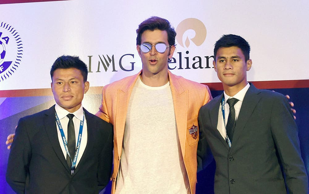 Bollywood actor Hrithik Roshan (C), owner of FC Pune team with players Jackichand Singh and Eugeneson Lyngdoh at a press conference after the Indian Super League auction and draft 2015.