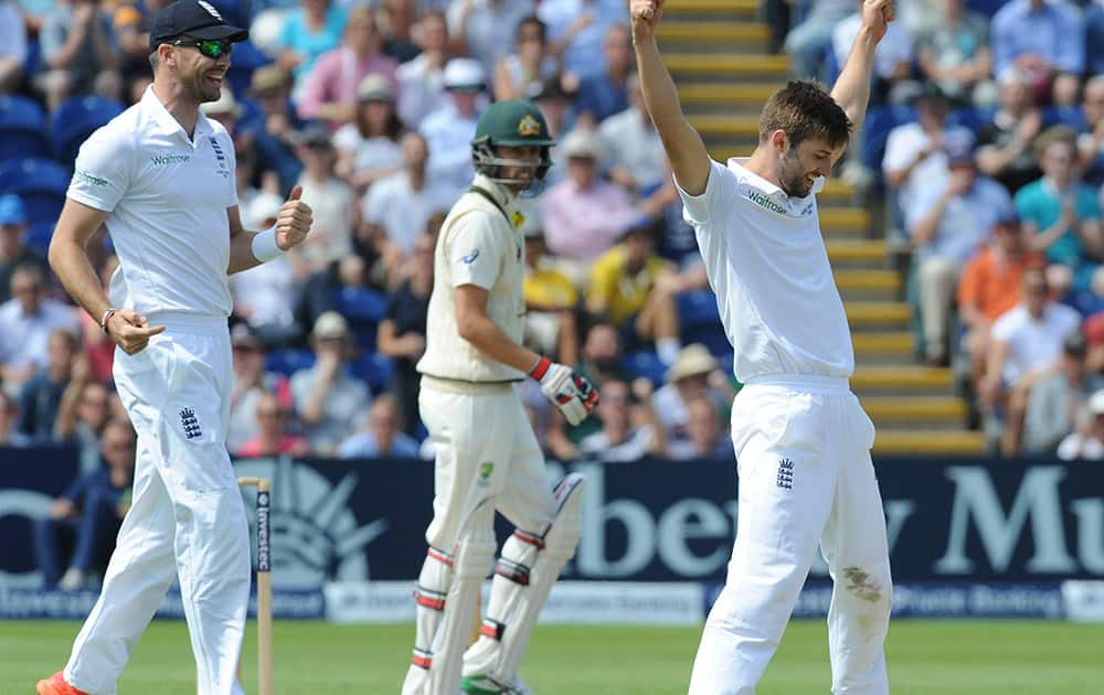 England’s Mark Wood celebrates with James Anderson after trapping Australia’s Nathan Lyon, LBW for 11 runs during day three of the first Ashes Test cricket match, in Cardiff, Wales.