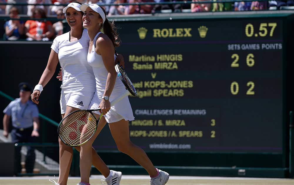 Martina Hingis of Switzerland celebrates with partner Sania Mirza of India as they win their women's semifinal doubles match against Raquel Kops-Jones of the United States and Abigail Spears of the United States, at the All England Lawn Tennis Championships in Wimbledon, London.